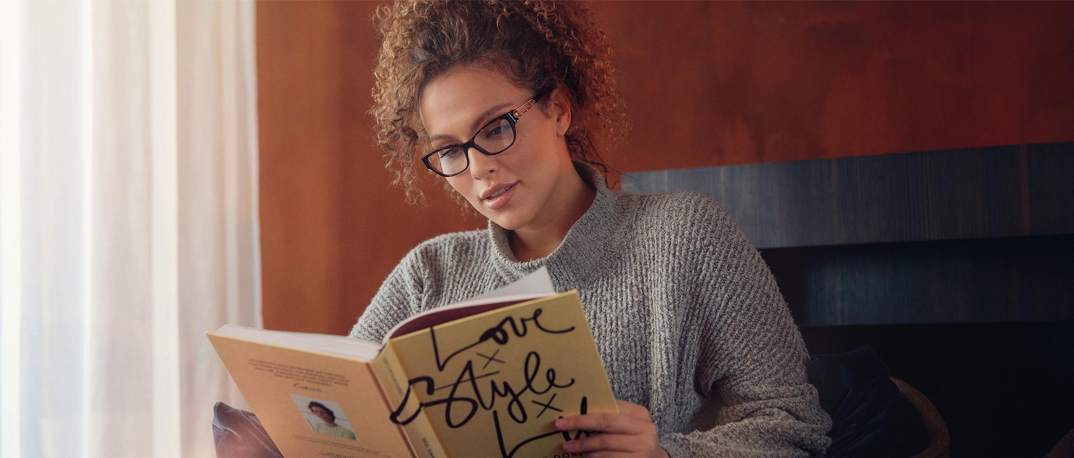 Kvinde med smarte læsebriller læser i en bog