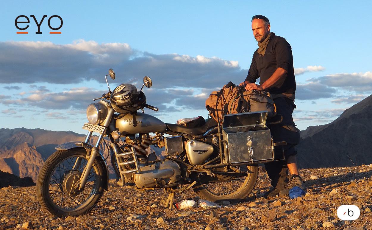 Shades of Love-Gründer und eYo-Ambassador Jürgen Altmann steht im Hochgebirge des Himalaya neben seinem Motorrad.
