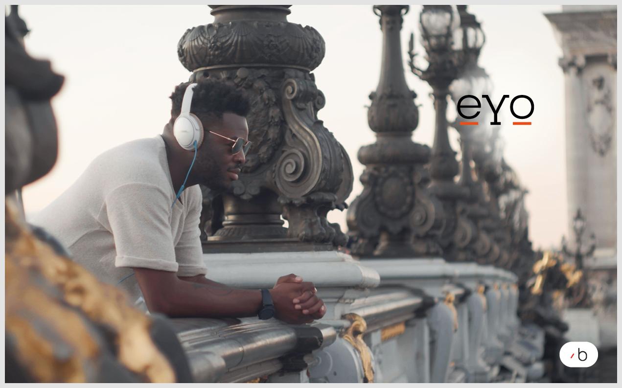 DJ Toni Vegas lehnt über ein Brückengeländer und trägt Kopfhörer und seine selbst designte eYo-Sonnenbrille.